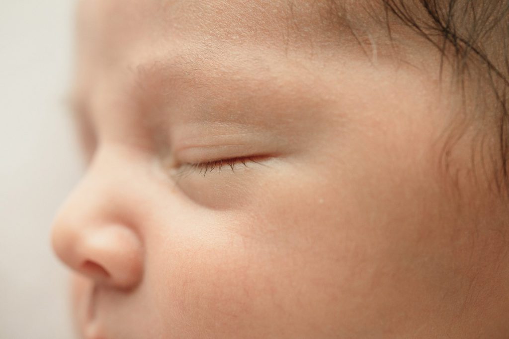 Close up detail of a newborn baby eyelashes during photo shoot.
