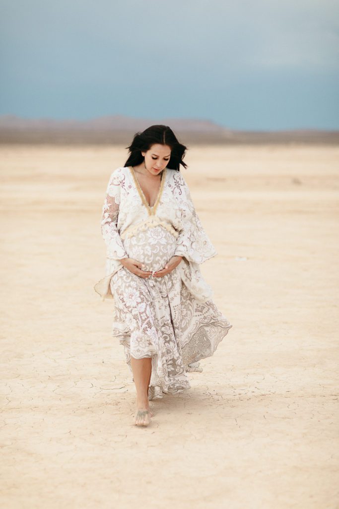 Expectant mama wearing a beautiful lace gown for her maternity photoshoot Orange County