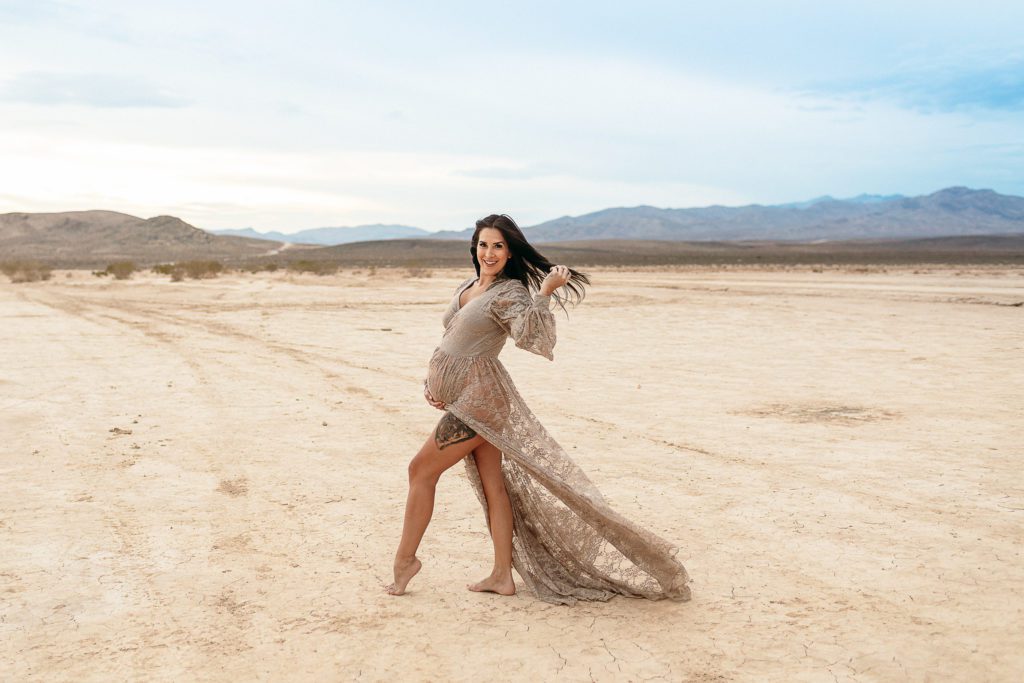 Maternity photo of a pregnant woman wearing a beige lace dress for her maternity photoshoot in Orange County
