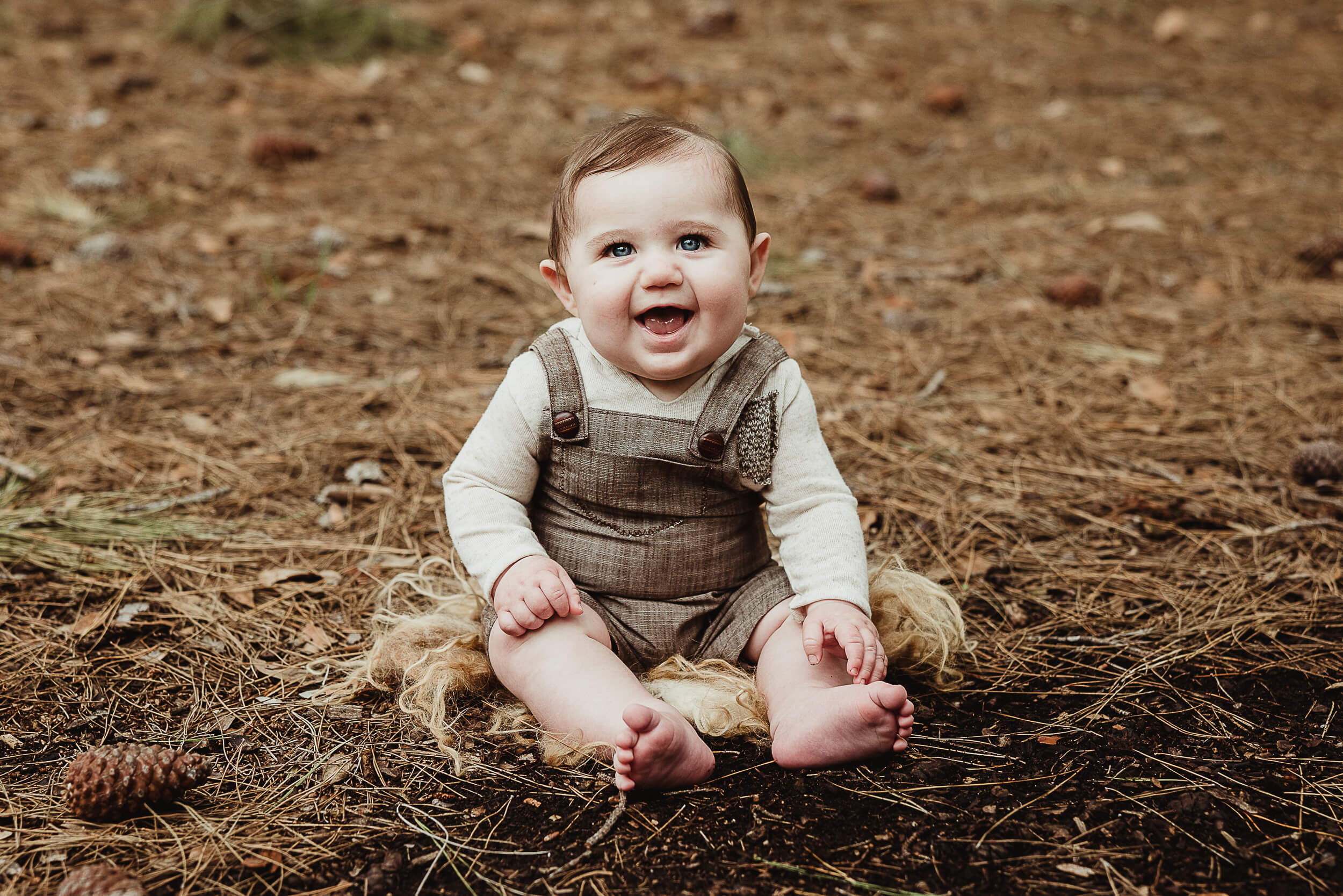 baby boy in brown overalls during his baby photography in orange county